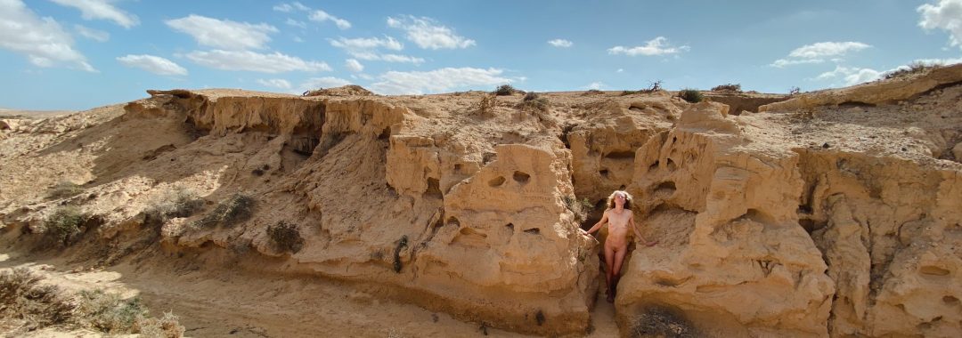 Bild einer unbekleideten Frau, zwischen den Felsen stehend, im Barranco de los Enamorados, Fuerteventura